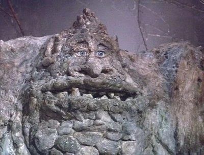 Gigante de pedra cinzenta com rosto enrugado