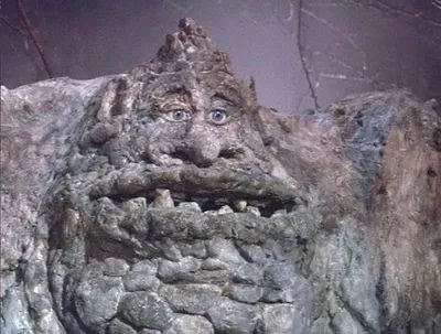 Gigante de pedra cinzenta com rosto enrugado