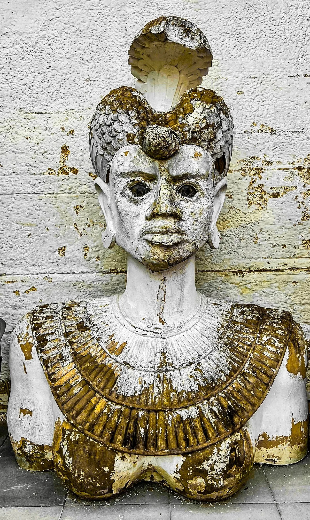Busto de esfinge prateada e dourada usado como peça cenográfica