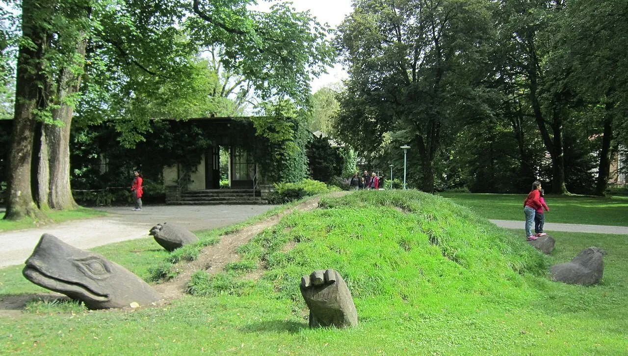 Escultura de tartaruga gigante semienterrada num gramado de parque