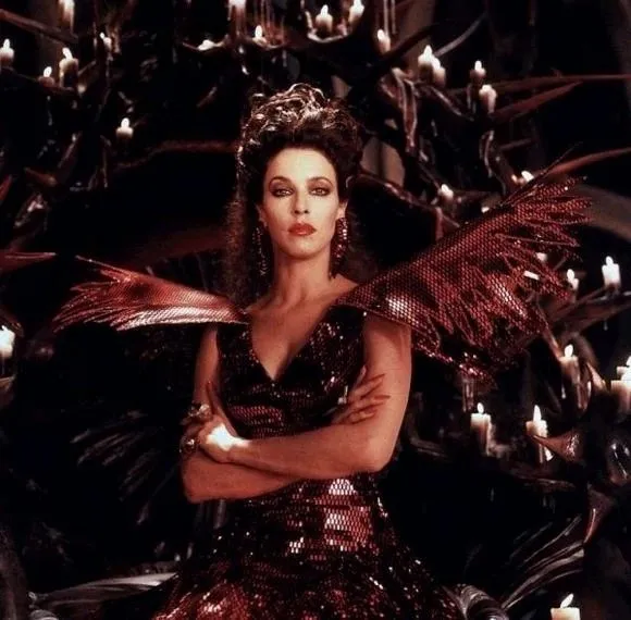 Feiticeira de vestido vermelho escuro e coroa, cercada de velas